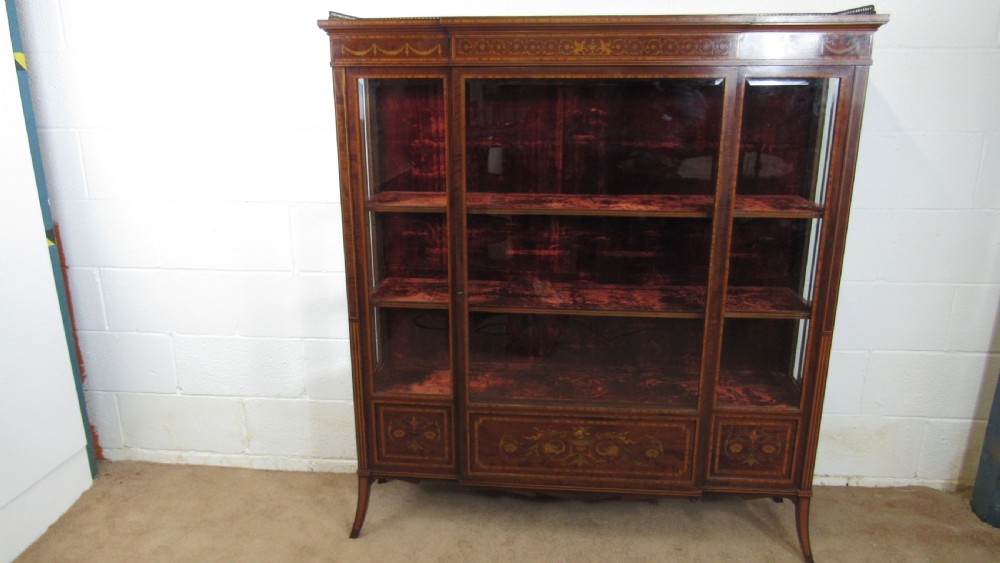 An Edwardian fiddleback mahogany display cabinet featuring glazed doors, detailed floral marquetry inlay on the lower panels, and square tapered legs. View V