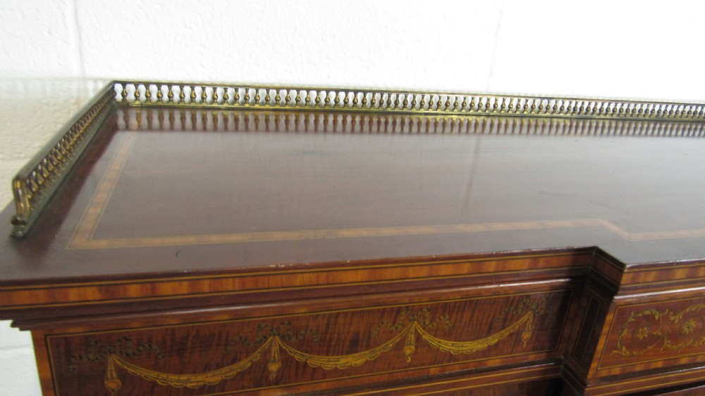 An Edwardian fiddleback mahogany display cabinet featuring glazed doors, detailed floral marquetry inlay on the lower panels, and square tapered legs. View VI