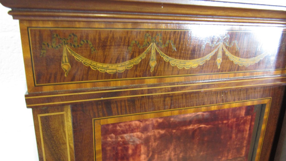 An Edwardian fiddleback mahogany display cabinet featuring glazed doors, detailed floral marquetry inlay on the lower panels, and square tapered legs. View VII