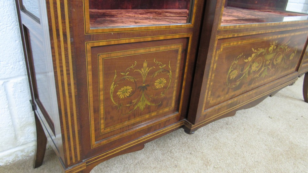 An Edwardian fiddleback mahogany display cabinet featuring glazed doors, detailed floral marquetry inlay on the lower panels, and square tapered legs. View IX