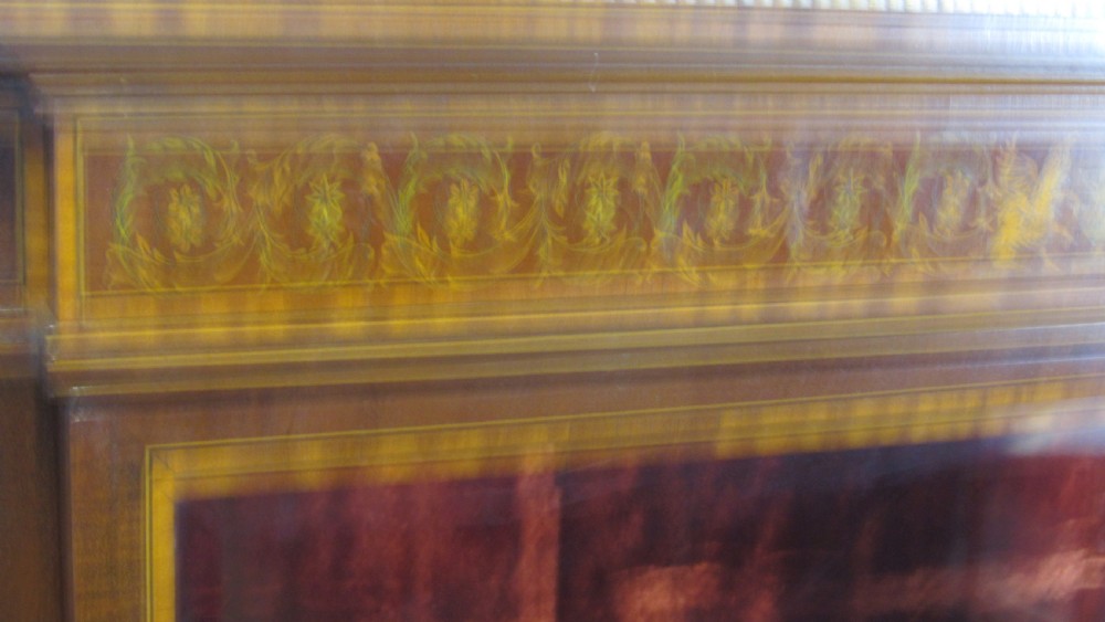 An Edwardian fiddleback mahogany display cabinet featuring glazed doors, detailed floral marquetry inlay on the lower panels, and square tapered legs. View XV