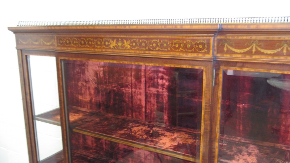 An Edwardian fiddleback mahogany display cabinet featuring glazed doors, detailed floral marquetry inlay on the lower panels, and square tapered legs. View XVII
