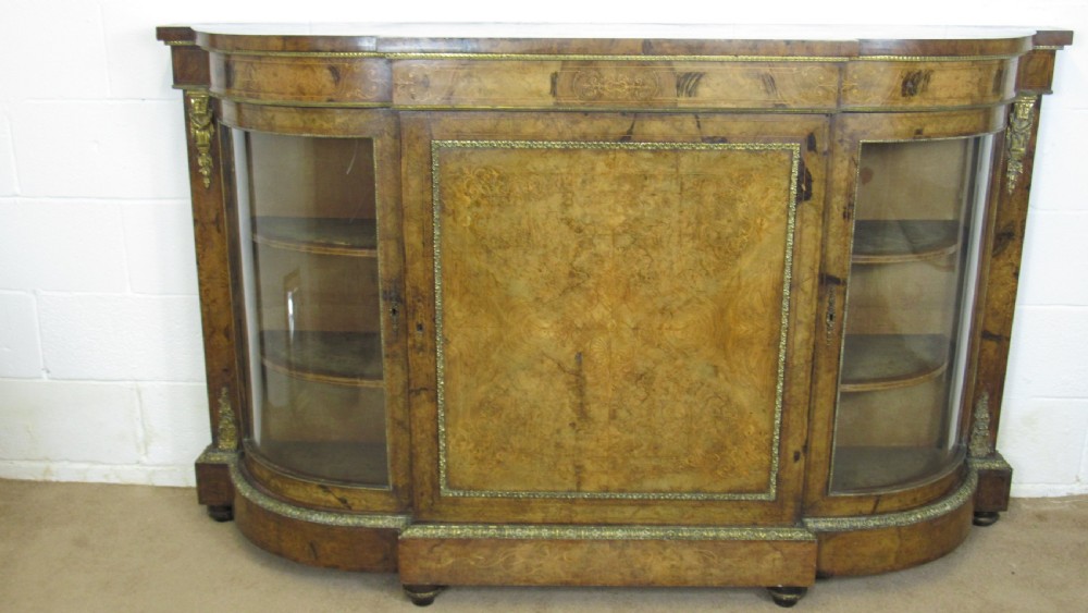 A Victorian burr walnut credenza featuring a central inlaid panel door flanked by two curved glazed display cupboards with gilt brass mounts. View II