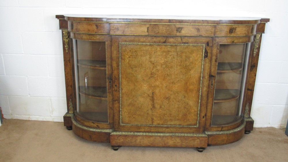 A Victorian burr walnut credenza featuring a central inlaid panel door flanked by two curved glazed display cupboards with gilt brass mounts. View III