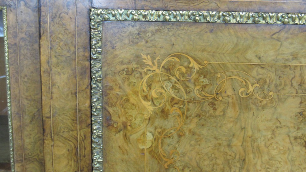 A Victorian burr walnut credenza featuring a central inlaid panel door flanked by two curved glazed display cupboards with gilt brass mounts. View X