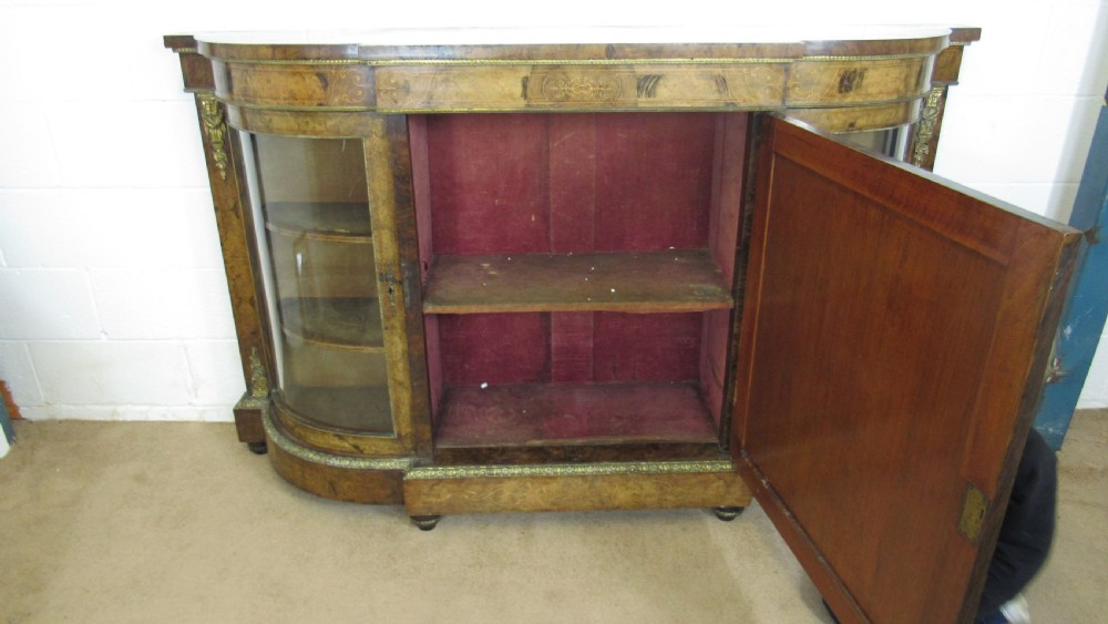 A Victorian burr walnut credenza featuring a central inlaid panel door flanked by two curved glazed display cupboards with gilt brass mounts. View XIV