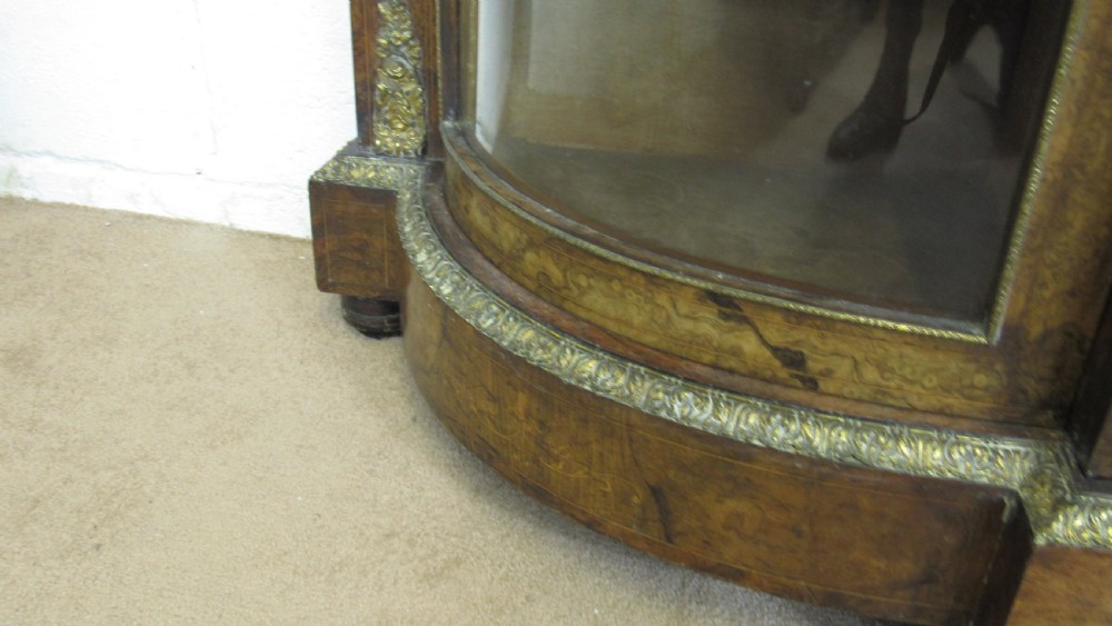 A Victorian burr walnut credenza featuring a central inlaid panel door flanked by two curved glazed display cupboards with gilt brass mounts. View XV