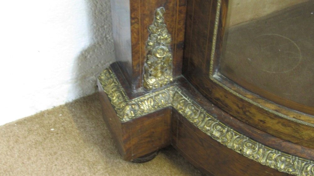 A Victorian burr walnut credenza featuring a central inlaid panel door flanked by two curved glazed display cupboards with gilt brass mounts. View XVII