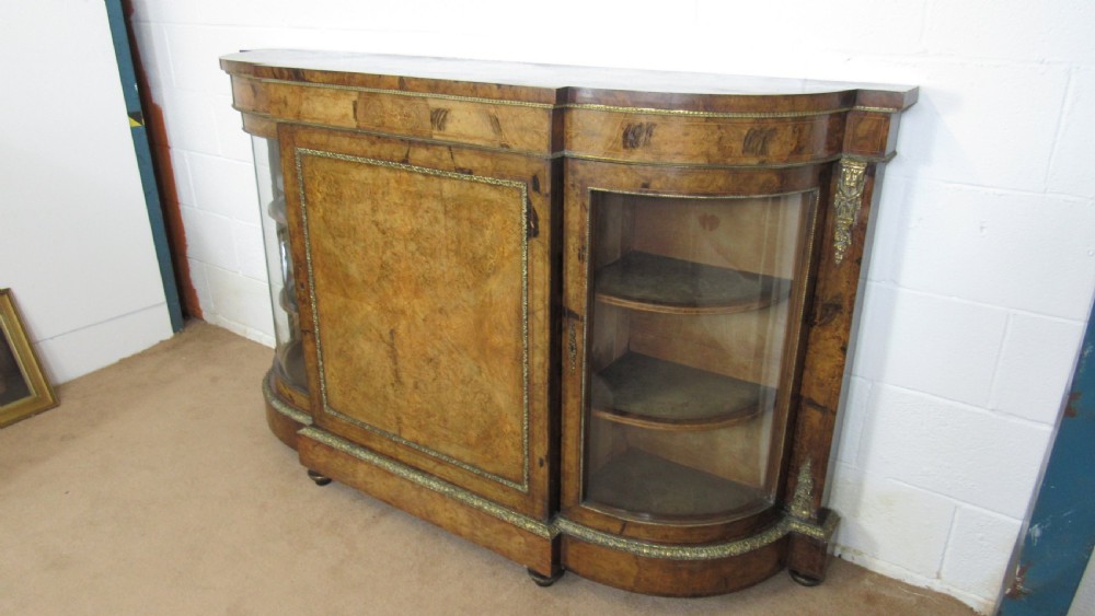 A Victorian burr walnut credenza featuring a central inlaid panel door flanked by two curved glazed display cupboards with gilt brass mounts. View XX