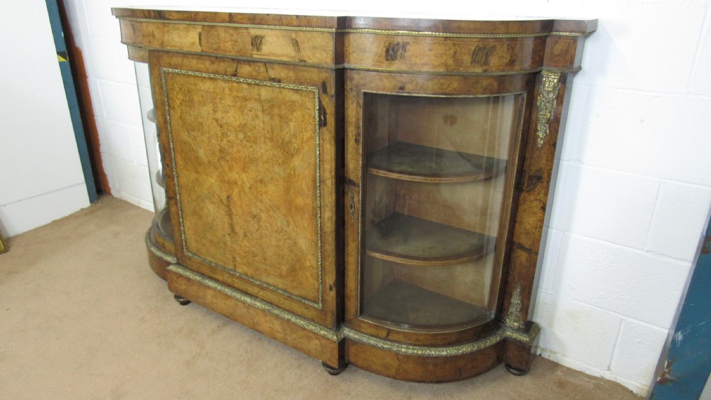 A Victorian burr walnut credenza featuring a central inlaid panel door flanked by two curved glazed display cupboards with gilt brass mounts. View XXI