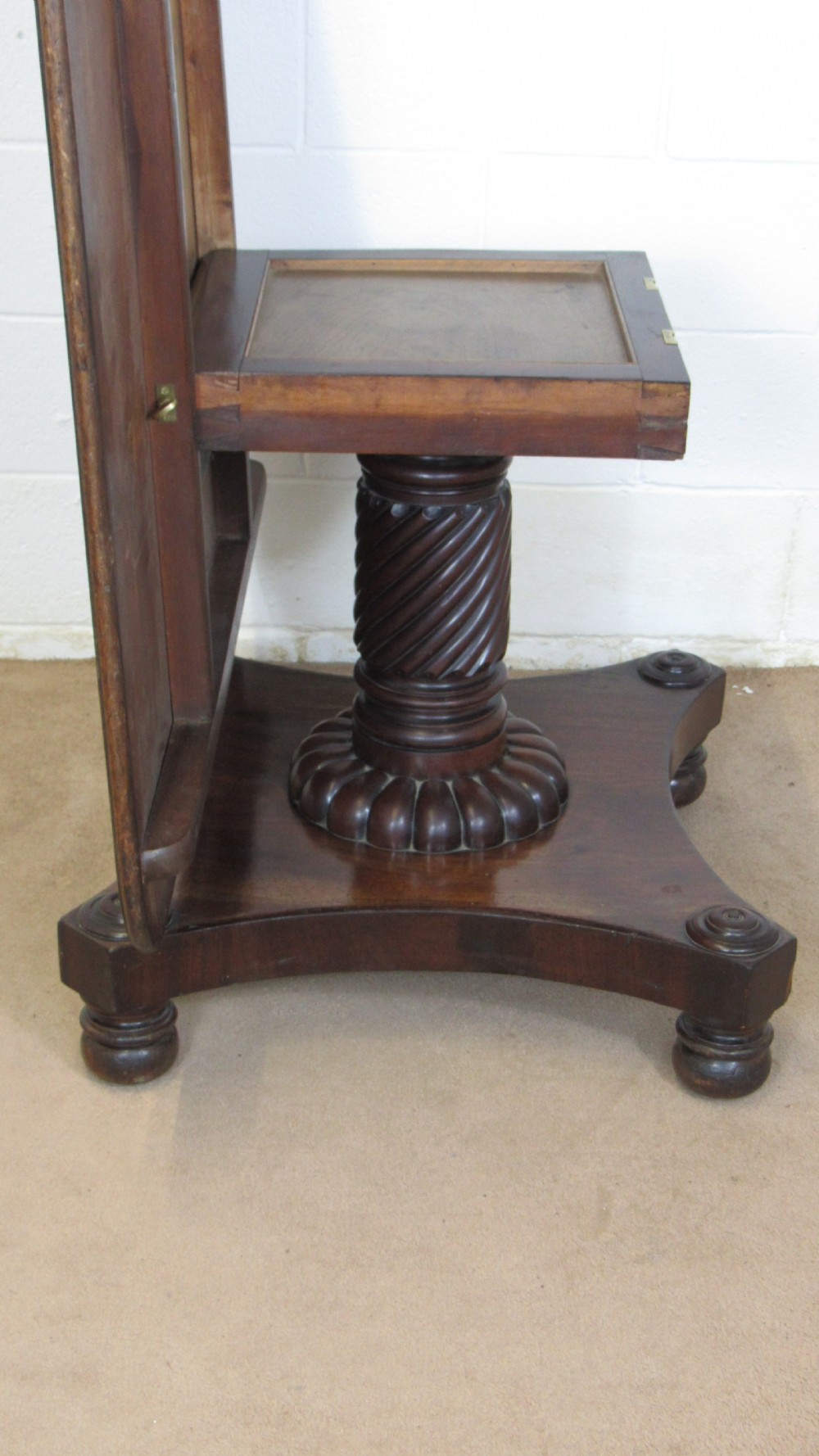 A 19th-century mahogany tilt-top centre table positioned vertically to show its flame-veneered surface and crossbanded border on a central pedestal base. View VIII