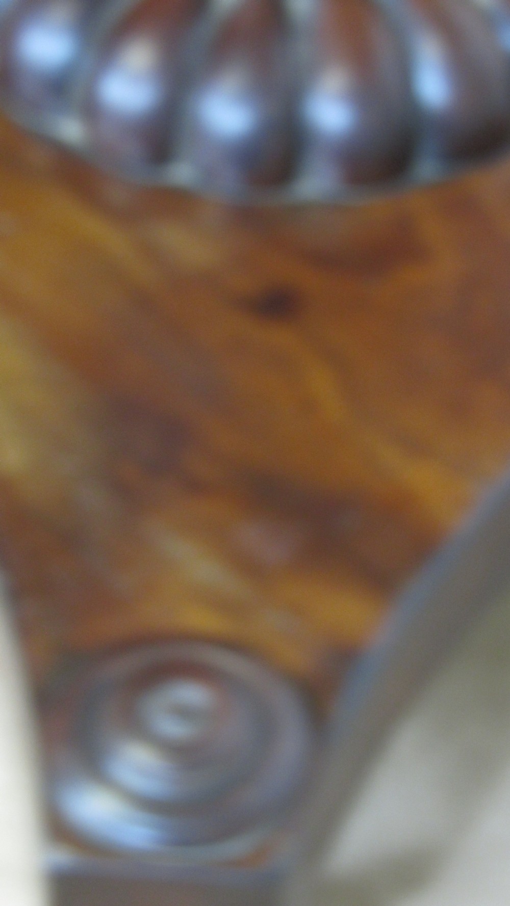 A 19th-century mahogany tilt-top centre table positioned vertically to show its flame-veneered surface and crossbanded border on a central pedestal base. View XII