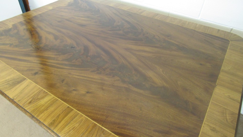 A 19th-century mahogany tilt-top centre table positioned vertically to show its flame-veneered surface and crossbanded border on a central pedestal base. View XVIII