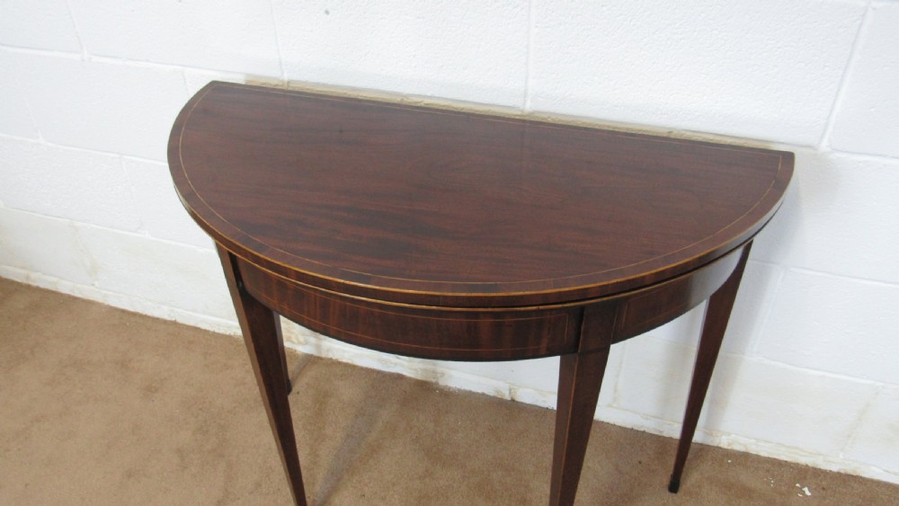 A Georgian mahogany demi-lune card table with linear string inlay and tapered square legs. View III