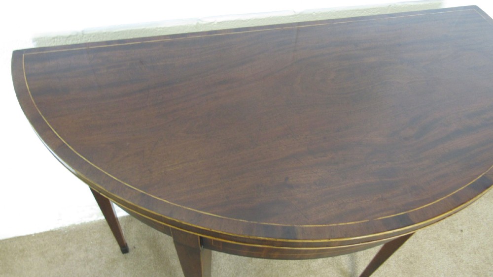 A Georgian mahogany demi-lune card table with linear string inlay and tapered square legs. View VI