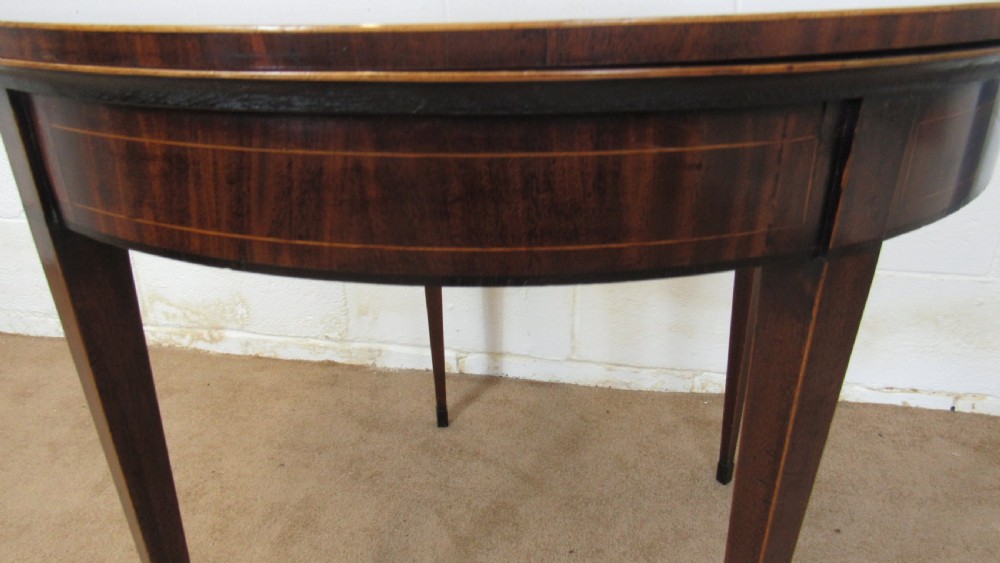 A Georgian mahogany demi-lune card table with linear string inlay and tapered square legs. View XIV