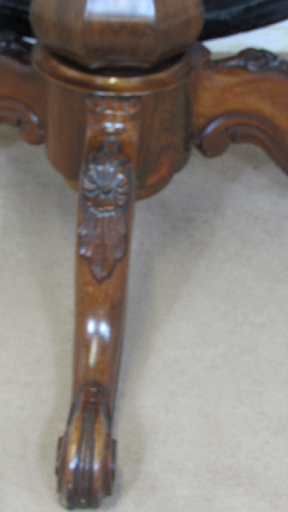 A circular antique rosewood tilt-top table shown in a vertical tilted position, displaying figured timber grain and a carved tripod base. View VIII