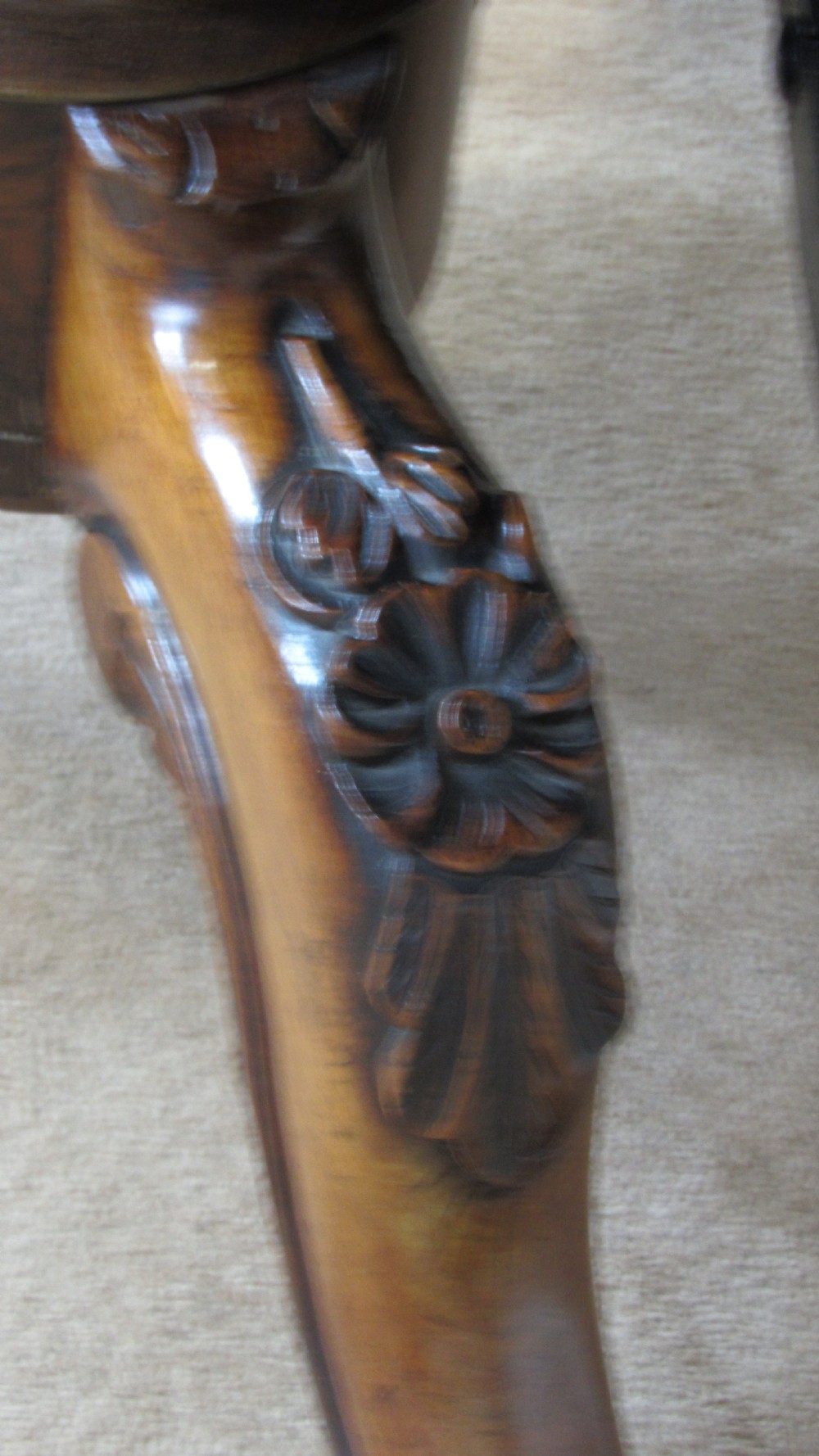 A circular antique rosewood tilt-top table shown in a vertical tilted position, displaying figured timber grain and a carved tripod base. View X