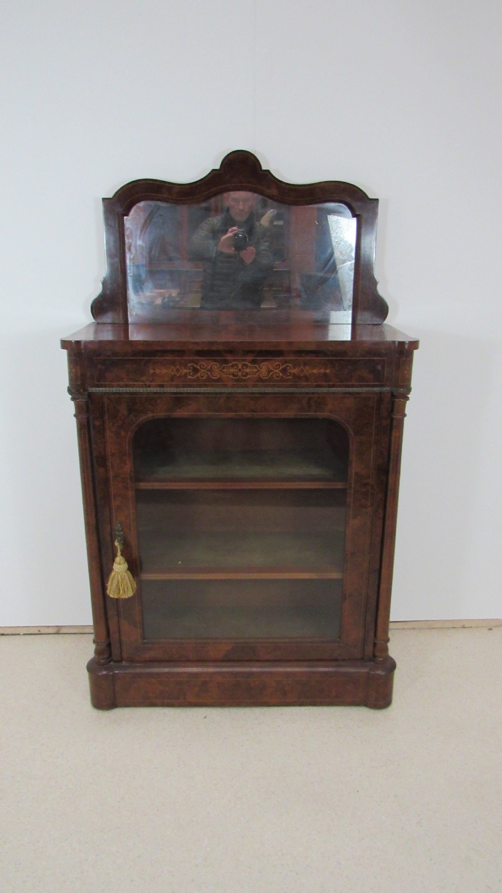 Victorian burr walnut pier cabinet featuring a glazed single door, scrollwork marquetry inlay, side columns, and an arched mirror back. View VII