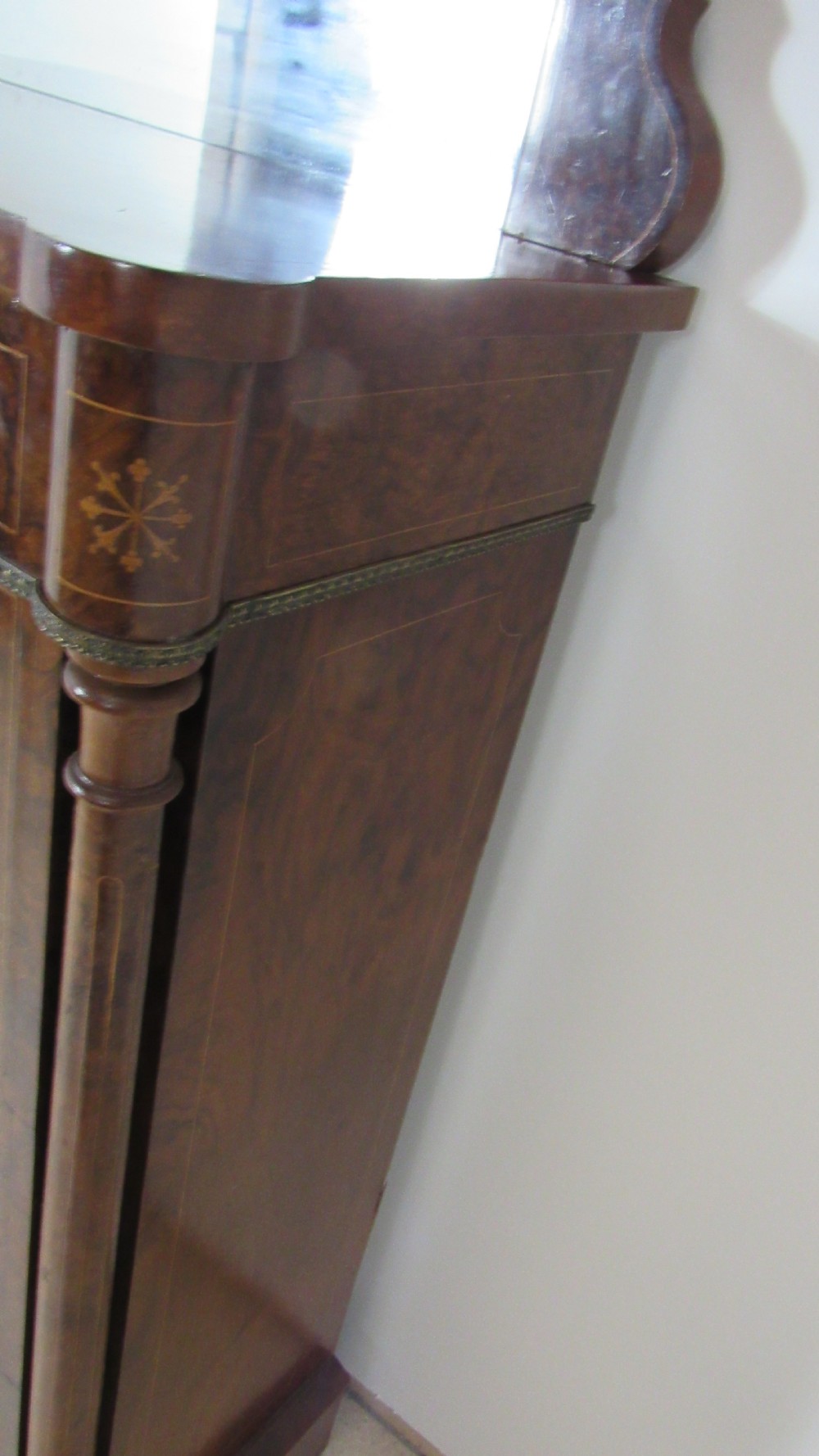 Victorian burr walnut pier cabinet featuring a glazed single door, scrollwork marquetry inlay, side columns, and an arched mirror back. View X