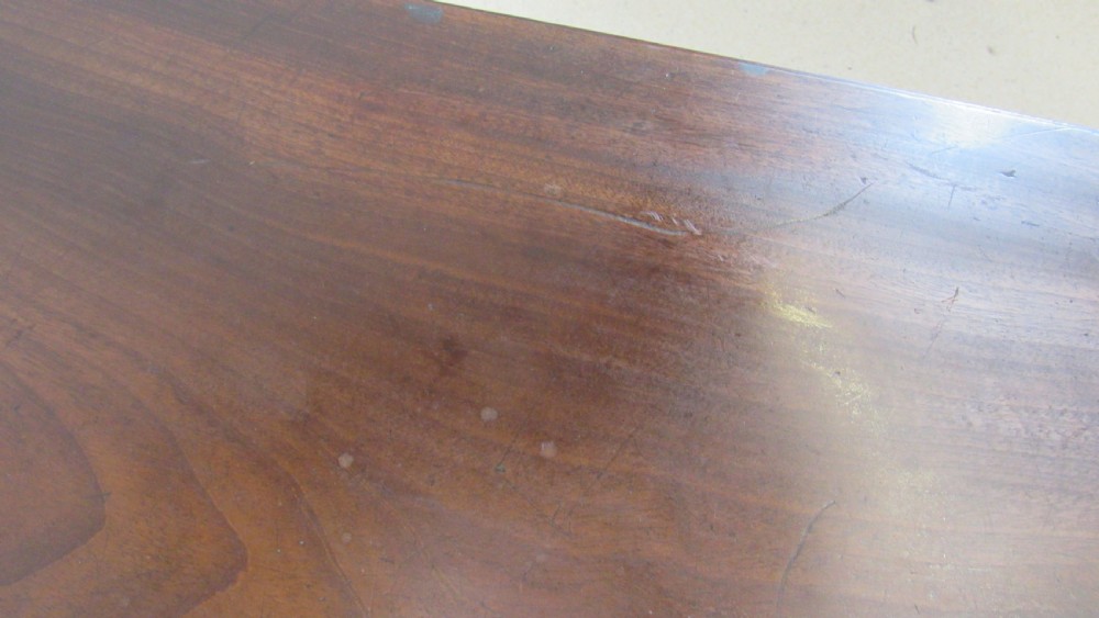 A dark mahogany Pembroke table with two drop leaves, turned legs on brass castors, and a single end drawer with wooden knobs. View V