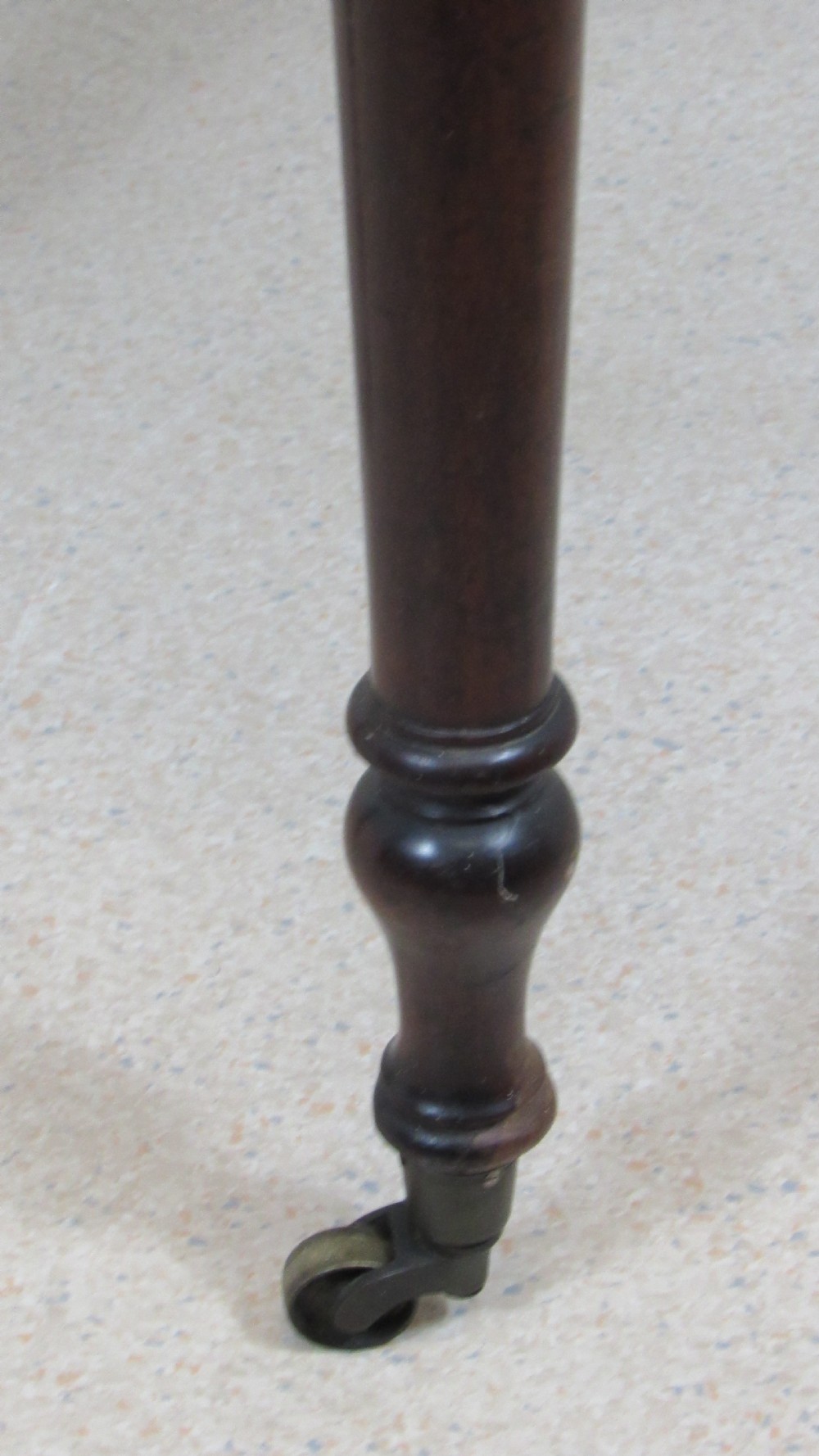 A dark mahogany Pembroke table with two drop leaves, turned legs on brass castors, and a single end drawer with wooden knobs. View X
