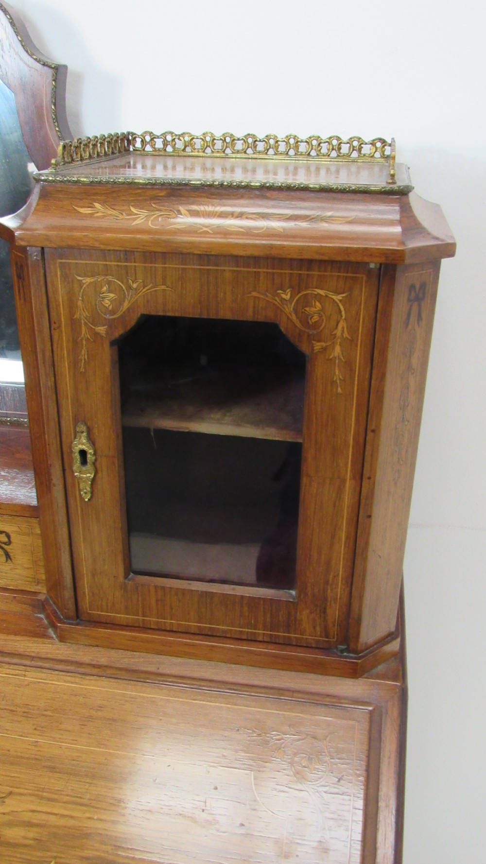 An antique French-style walnut writing bureau with floral marquetry, cabriole legs, brass mounts, and a upper cabinet section featuring small glazed doors and a central mirror. View VIII