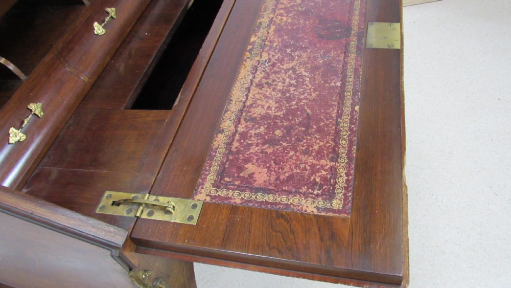 An antique French-style walnut writing bureau with floral marquetry, cabriole legs, brass mounts, and a upper cabinet section featuring small glazed doors and a central mirror. View XVI