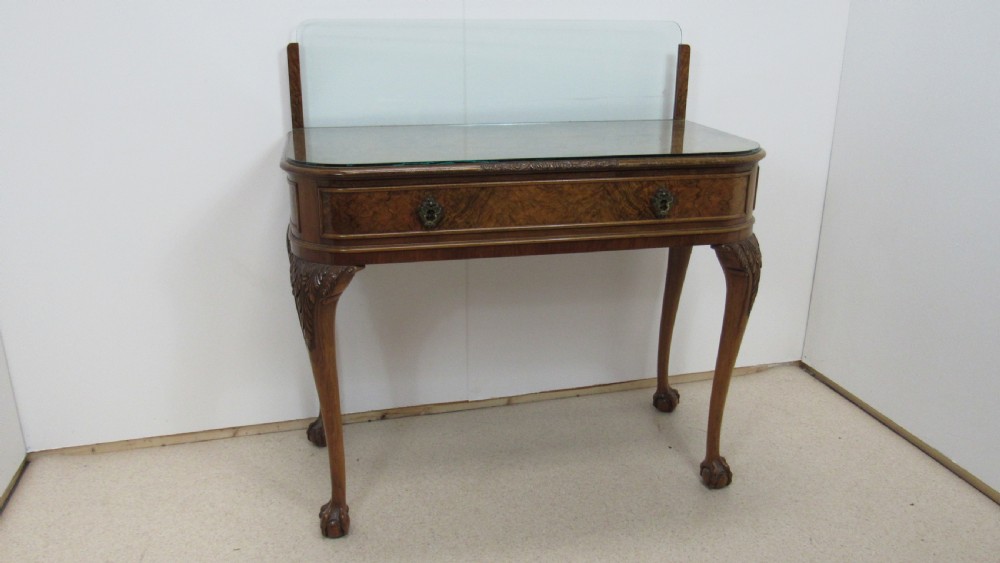 An antique burr walnut side table featuring cabriole legs with claw and ball feet, a single drawer, and a fitted glass top insert.