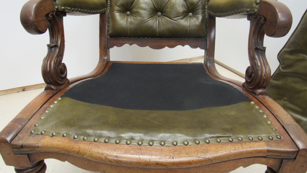 A William IV mahogany library chair upholstered in deep-buttoned olive green leather with padded scroll arms and turned front legs on brass castors. View VII