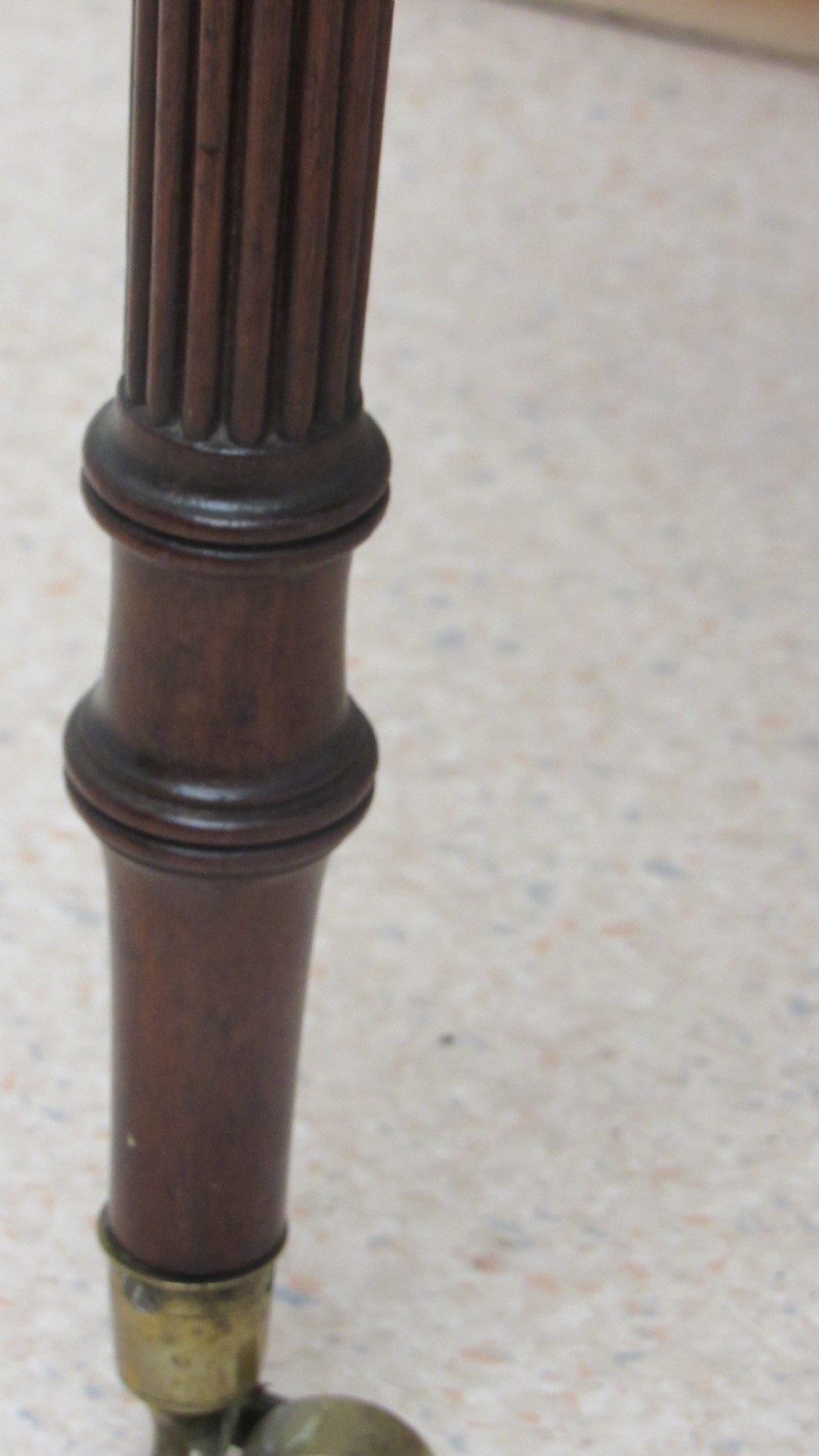 A Regency mahogany chamber table featuring reeded tapered legs on brass castors, a central drawer with wooden knobs, and a hinged lid top. View X