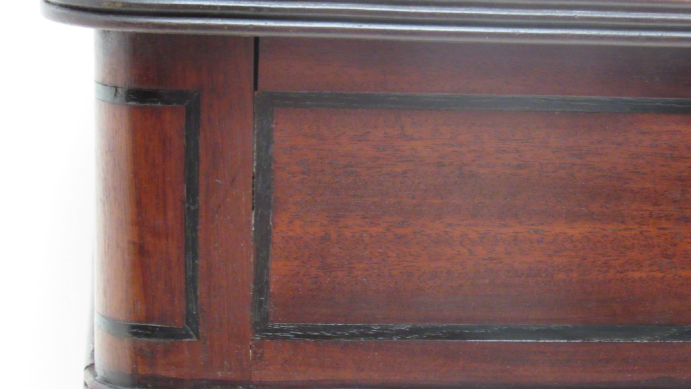A Regency mahogany chamber table featuring reeded tapered legs on brass castors, a central drawer with wooden knobs, and a hinged lid top. View XVI