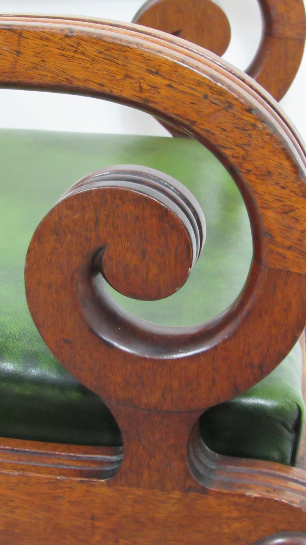 A pair of carved mahogany armchairs featuring scroll-carved top rails, curved armrests, reeded front rails, and green leather upholstered seats. View VII