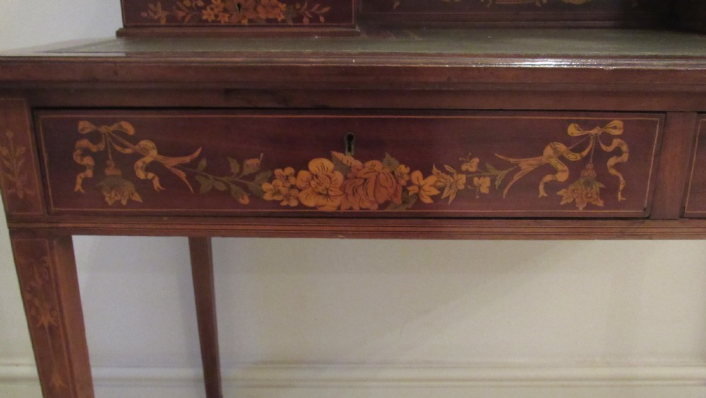 An Edwardian mahogany writing desk featuring detailed floral marquetry inlays, a green leather top, and raised stationery boxes with brass galleries. View VIII