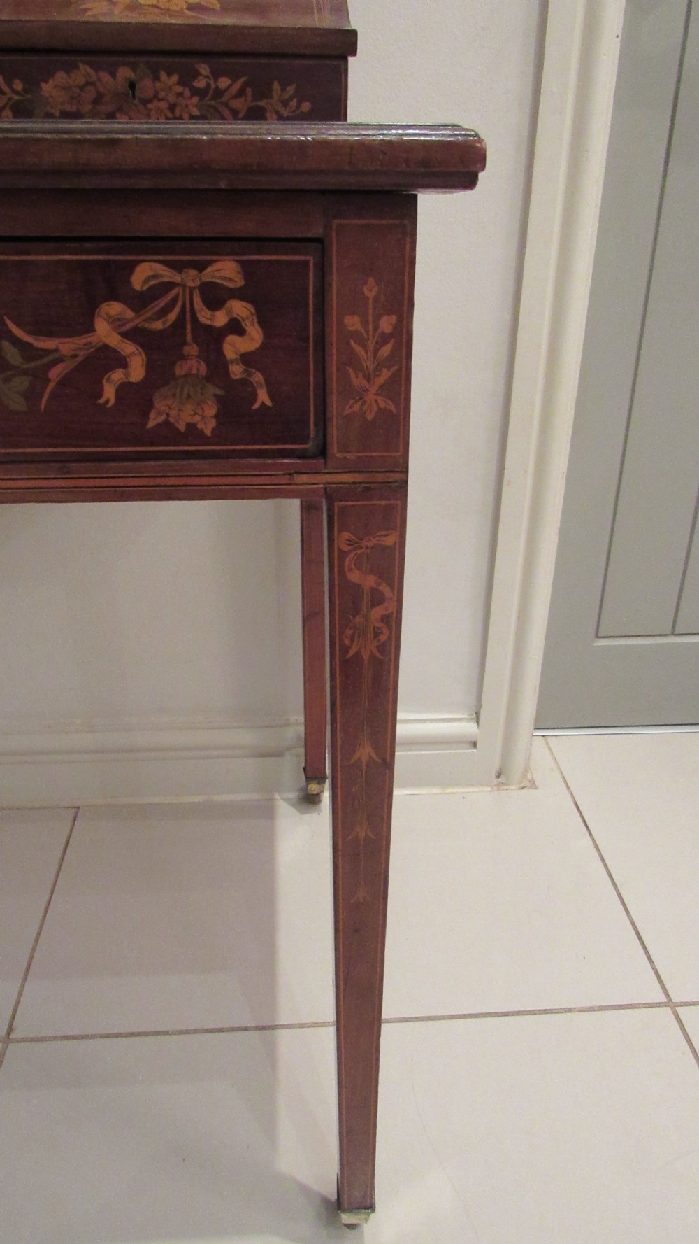 An Edwardian mahogany writing desk featuring detailed floral marquetry inlays, a green leather top, and raised stationery boxes with brass galleries. View XII