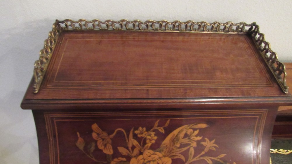 An Edwardian mahogany writing desk featuring detailed floral marquetry inlays, a green leather top, and raised stationery boxes with brass galleries. View XV