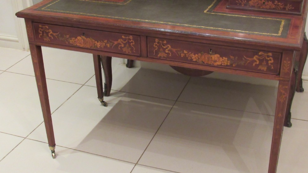 An Edwardian mahogany writing desk featuring detailed floral marquetry inlays, a green leather top, and raised stationery boxes with brass galleries. View XXI