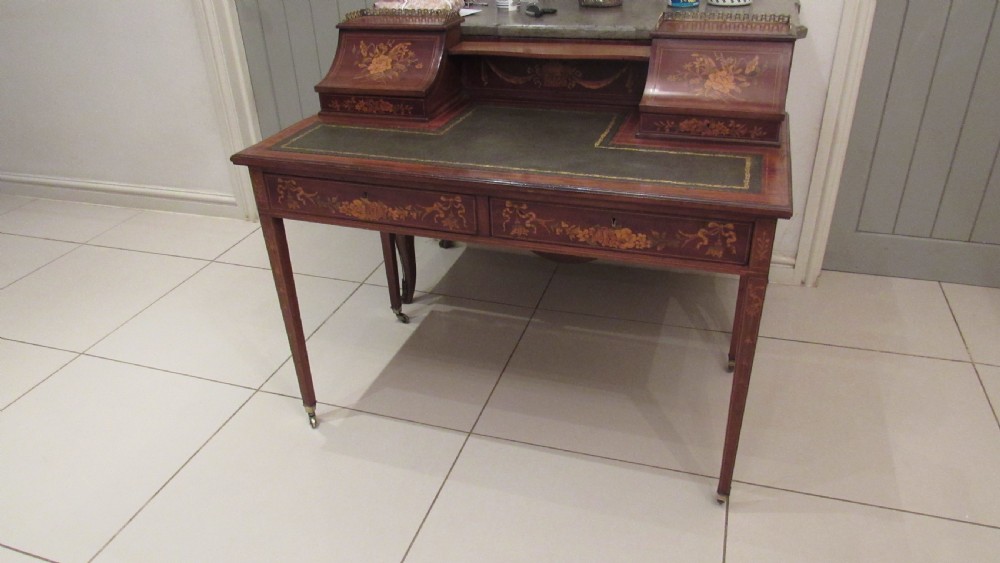 An Edwardian mahogany writing desk featuring detailed floral marquetry inlays, a green leather top, and raised stationery boxes with brass galleries. View XXIII
