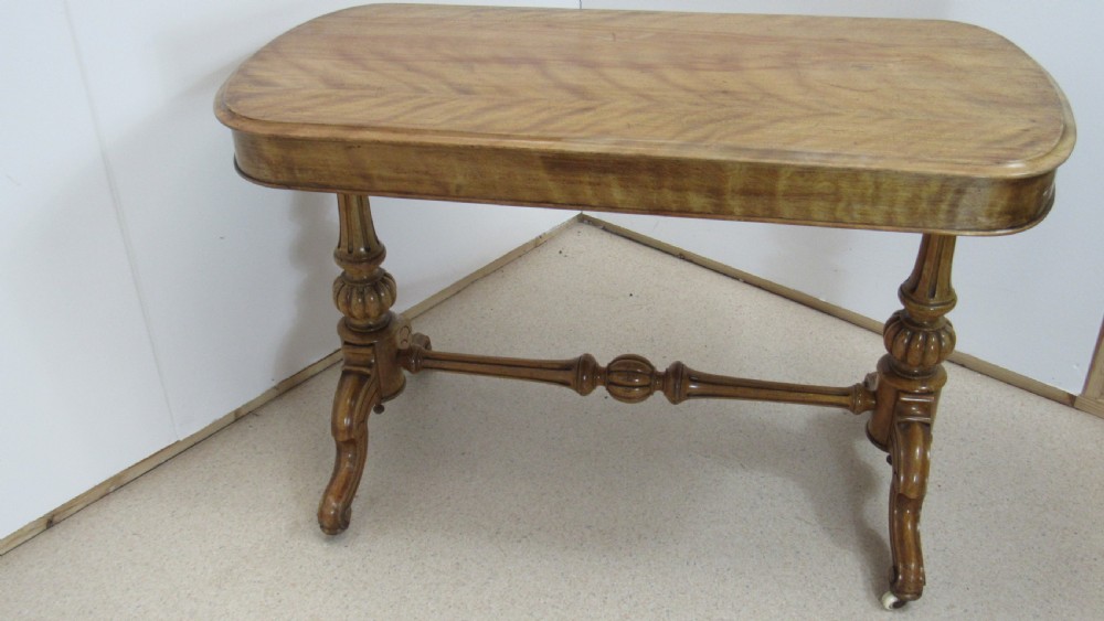 A Victorian satin walnut library table featuring a rectangular top with rounded corners, a pulled-out frieze drawer, turned pedestal legs, and a low central stretcher base. View XVII