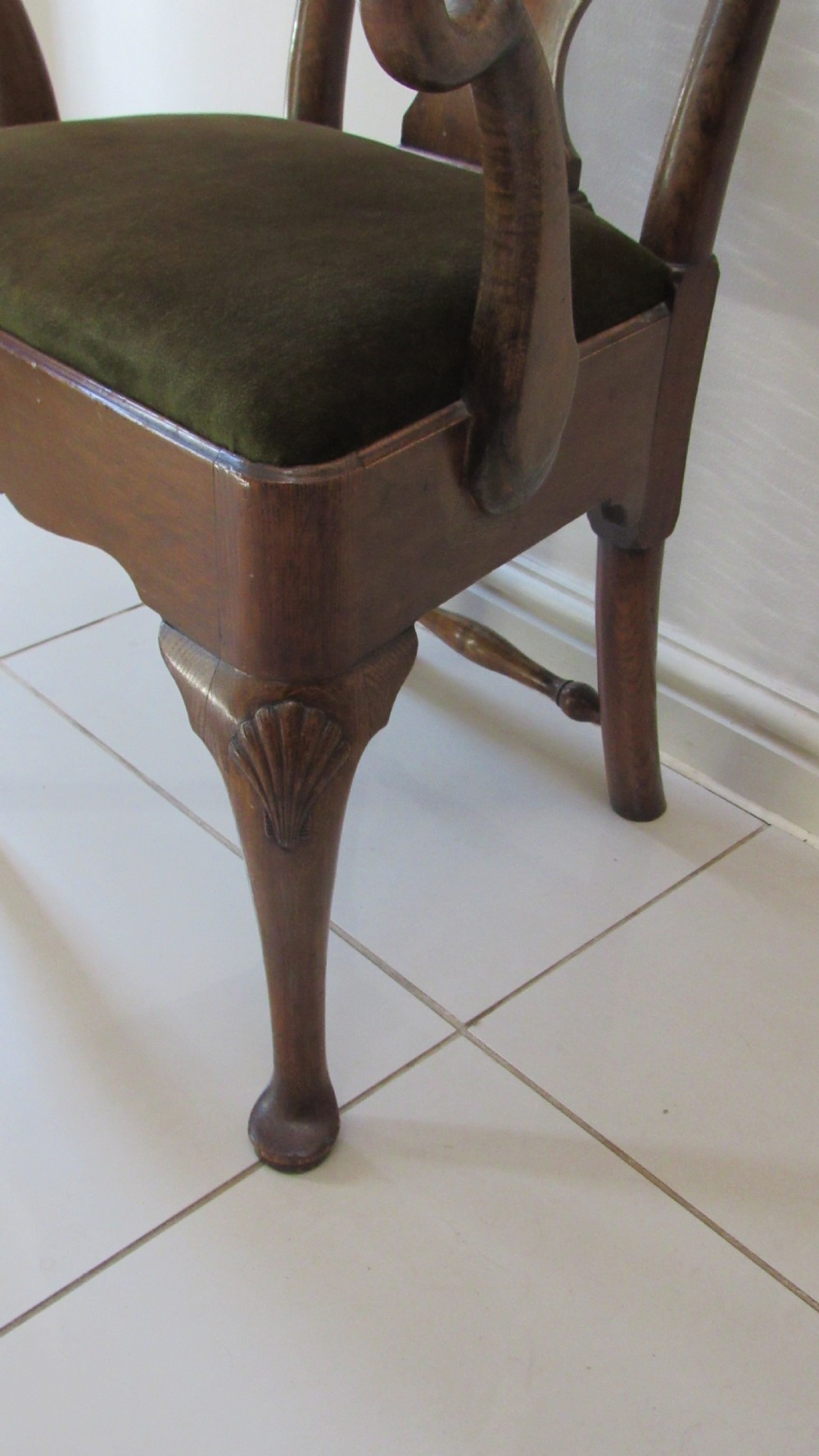 A miniature Queen Anne style childs armchair crafted from dark wood with a carved shell top rail, vasiform splat back, cabriole front legs, and a dark green velvet padded seat. View X