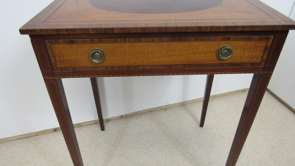 A 19th-century wooden side table featuring square tapered legs, a single drawer with brass handles, and a decorative oval inlaid top surface. View V