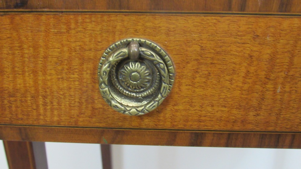 A 19th-century wooden side table featuring square tapered legs, a single drawer with brass handles, and a decorative oval inlaid top surface. View VI