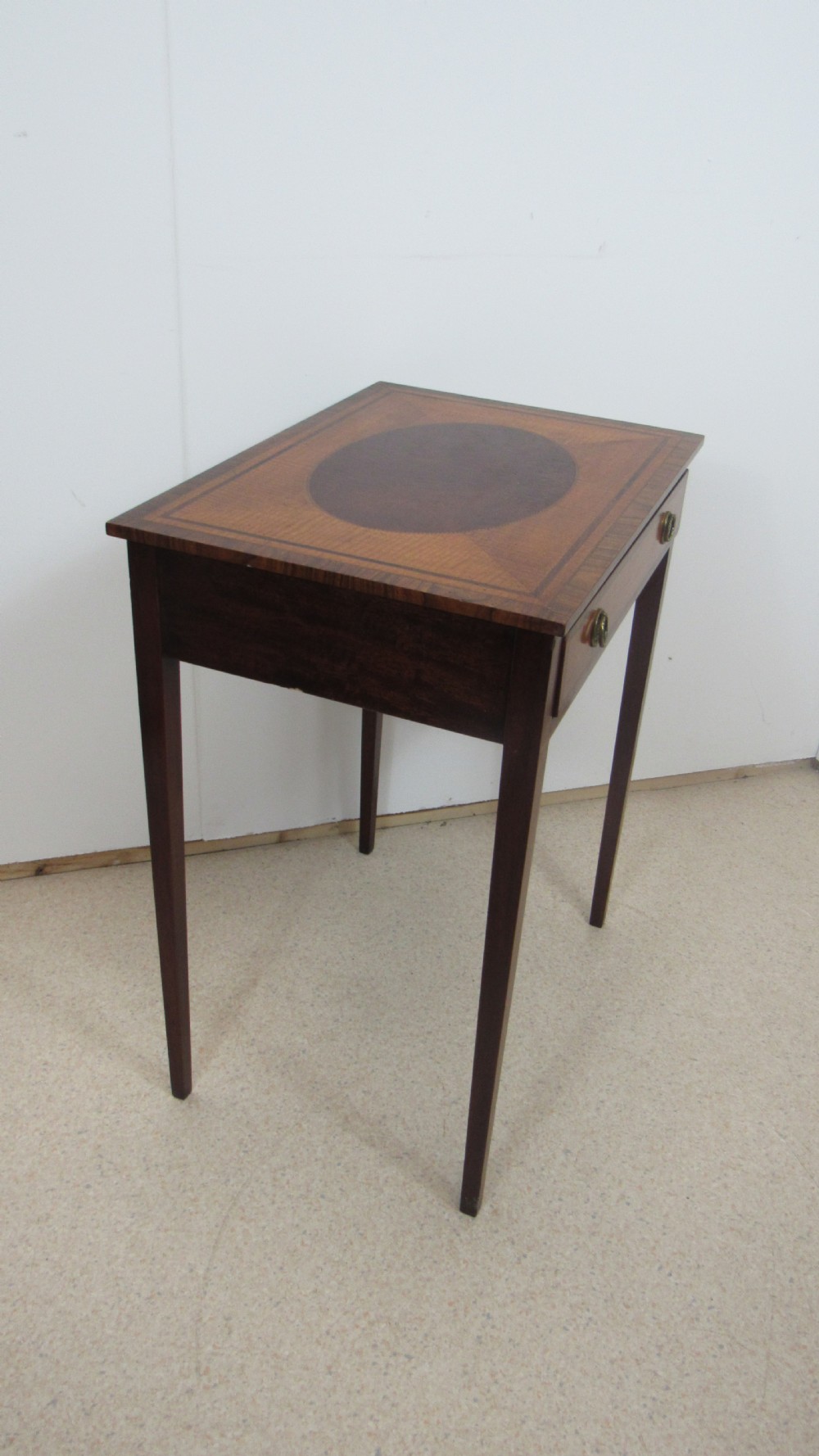 A 19th-century wooden side table featuring square tapered legs, a single drawer with brass handles, and a decorative oval inlaid top surface. View VII