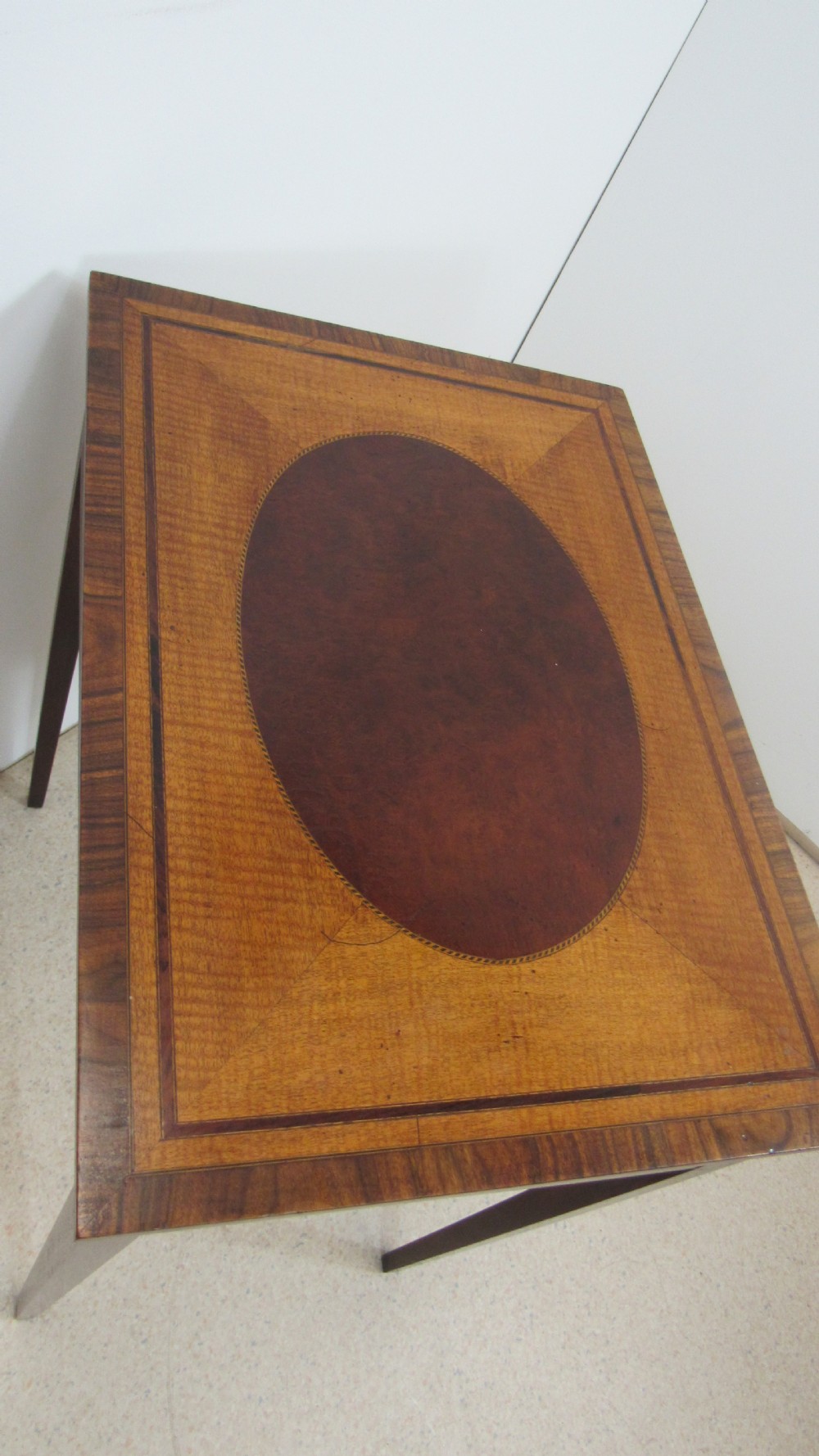 A 19th-century wooden side table featuring square tapered legs, a single drawer with brass handles, and a decorative oval inlaid top surface. View IX