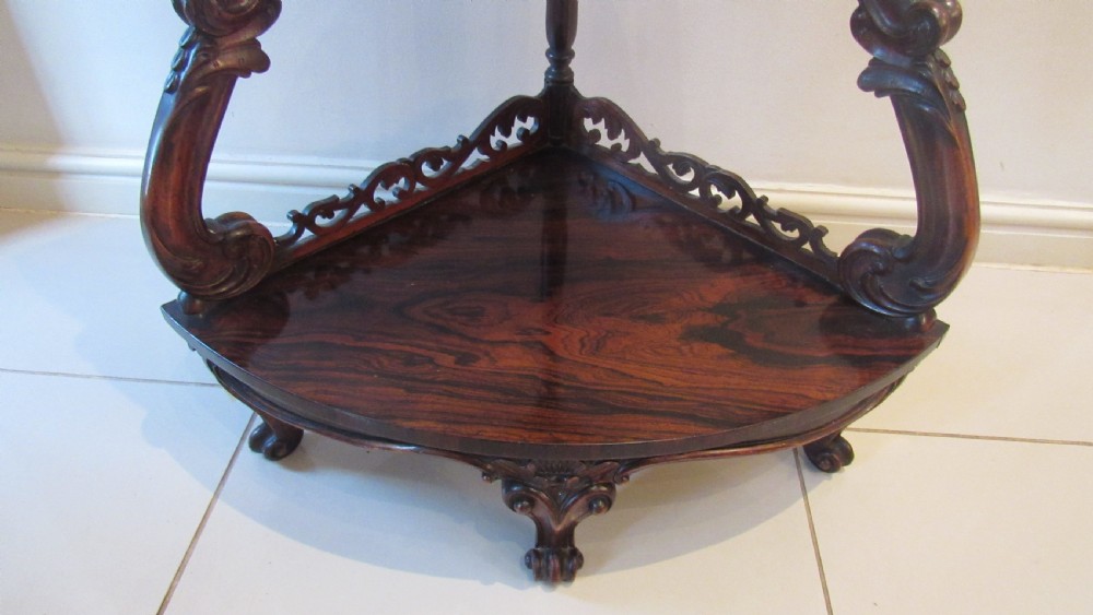 A three-tiered Victorian rosewood corner whatnot featuring intricate carved fretwork galleries, serpentine supports, and small carved feet. View IX