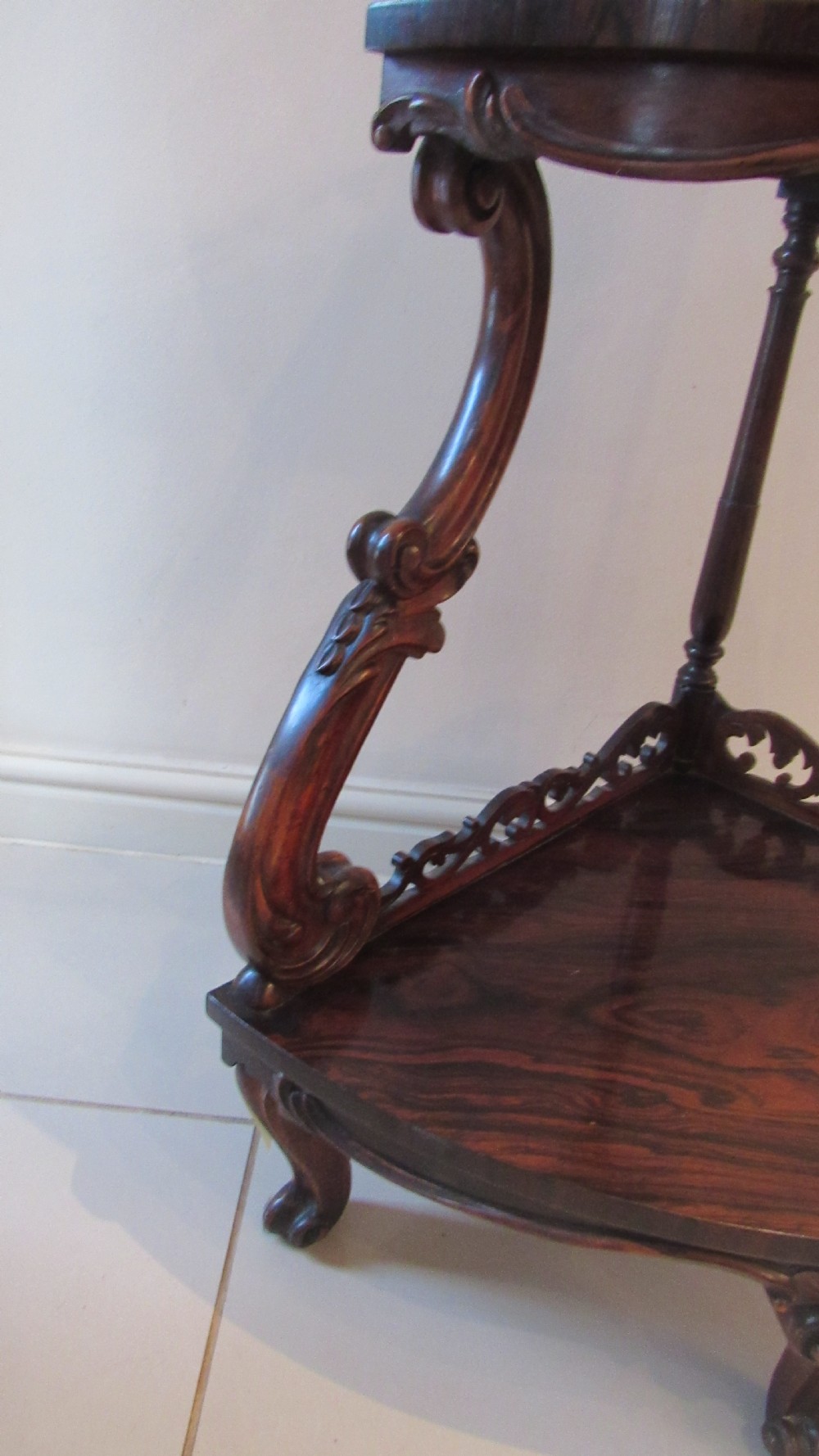 A three-tiered Victorian rosewood corner whatnot featuring intricate carved fretwork galleries, serpentine supports, and small carved feet. View XI