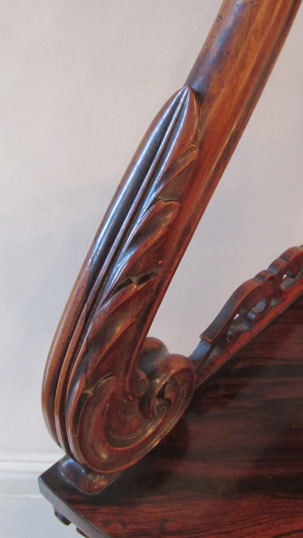 A three-tiered Victorian rosewood corner whatnot featuring intricate carved fretwork galleries, serpentine supports, and small carved feet. View XXV
