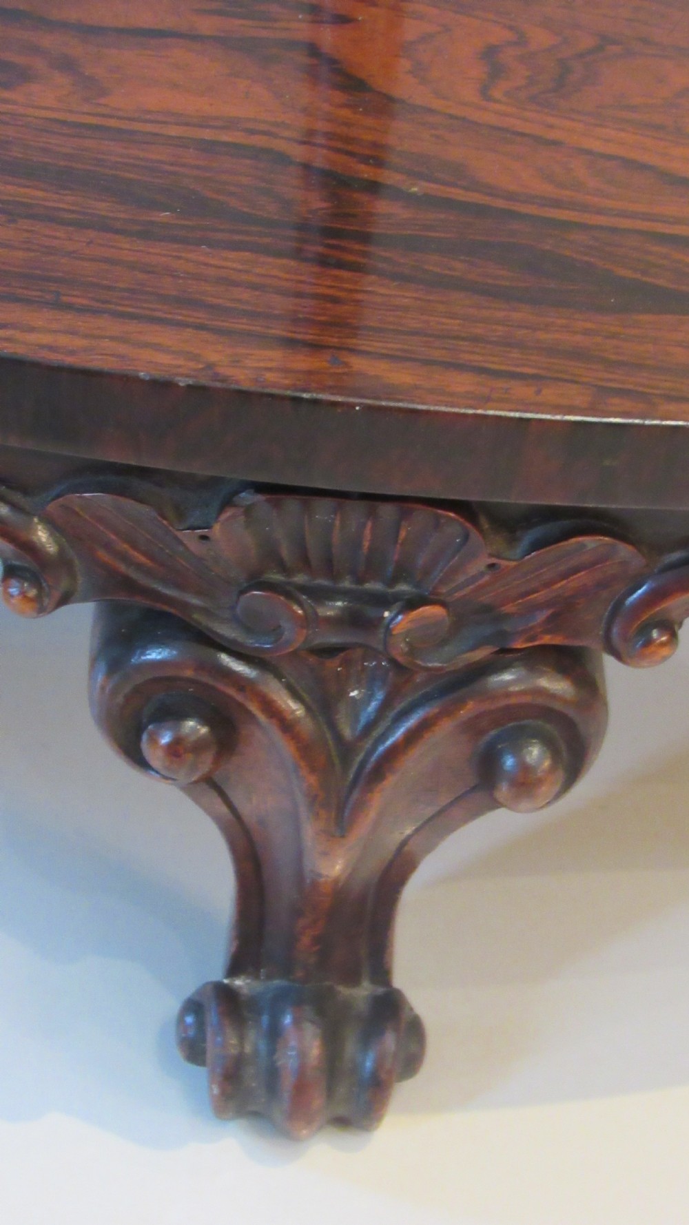 A three-tiered Victorian rosewood corner whatnot featuring intricate carved fretwork galleries, serpentine supports, and small carved feet. View XXIX