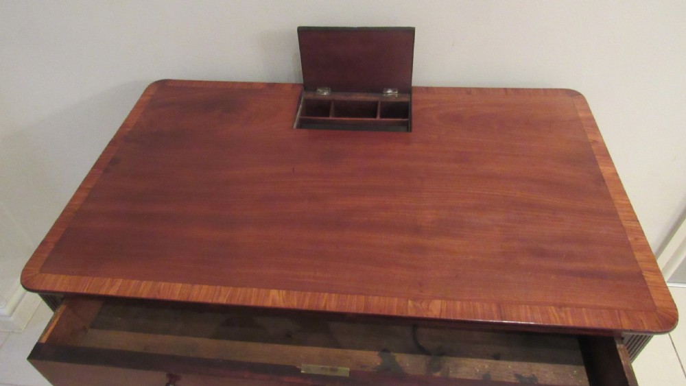 A Georgian mahogany chamber table featuring a rectangular top with a central flap, a single frieze drawer with brass hardware, and spiral turned legs on brass castors. View VI
