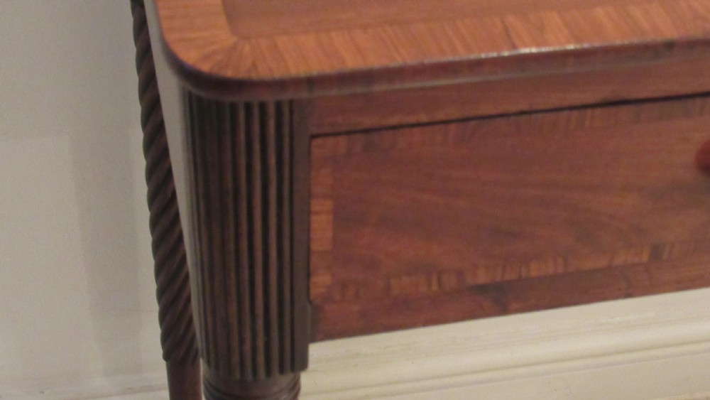 A Georgian mahogany chamber table featuring a rectangular top with a central flap, a single frieze drawer with brass hardware, and spiral turned legs on brass castors. View X